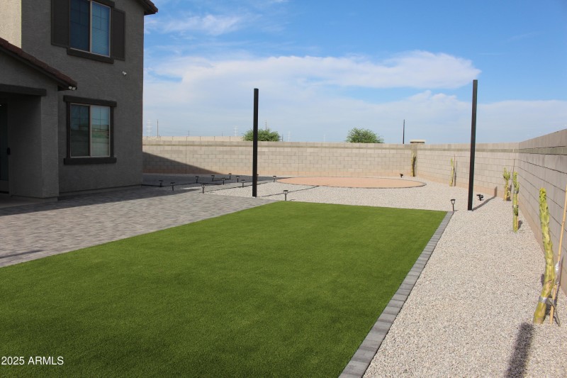Backyard by design with turf and pavers