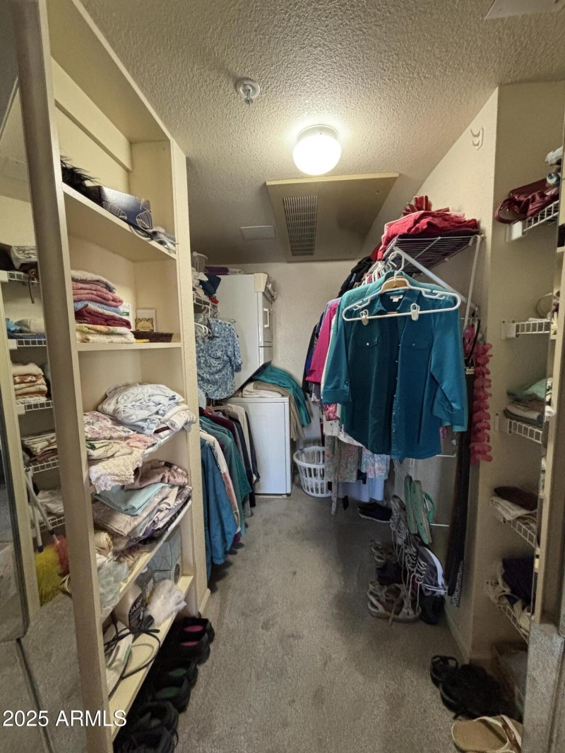 Large walk in closet with laundry area