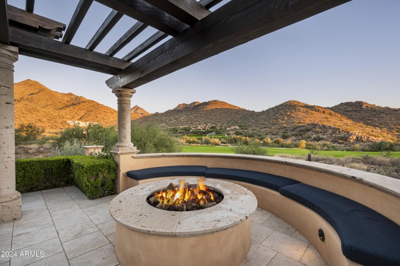 Firepit and trellis behind pool