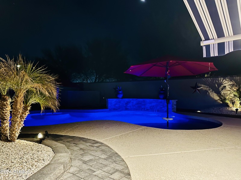 Night shot of the backyard and pool