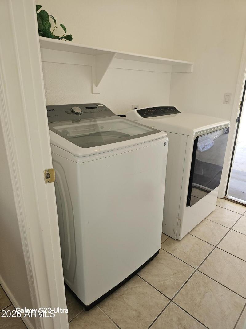 inside laundry room w/ built in shelve